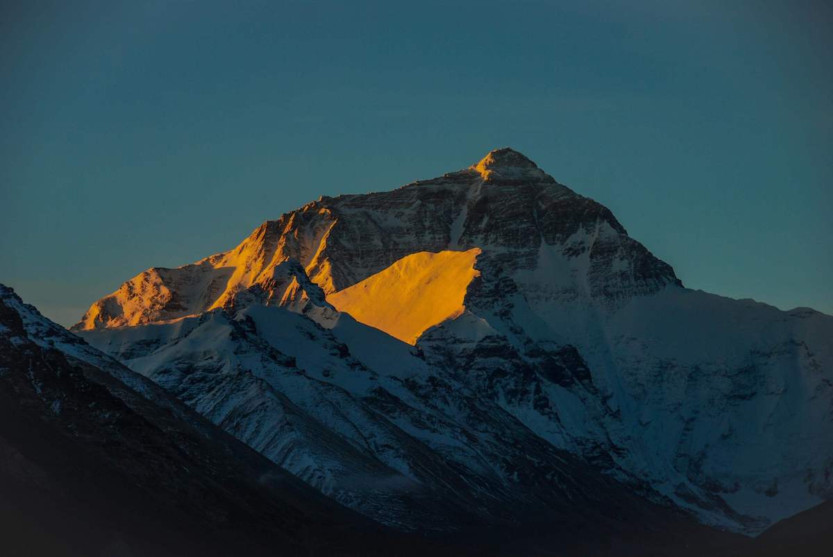 Image of a mountain top painted orange with the sun’s light